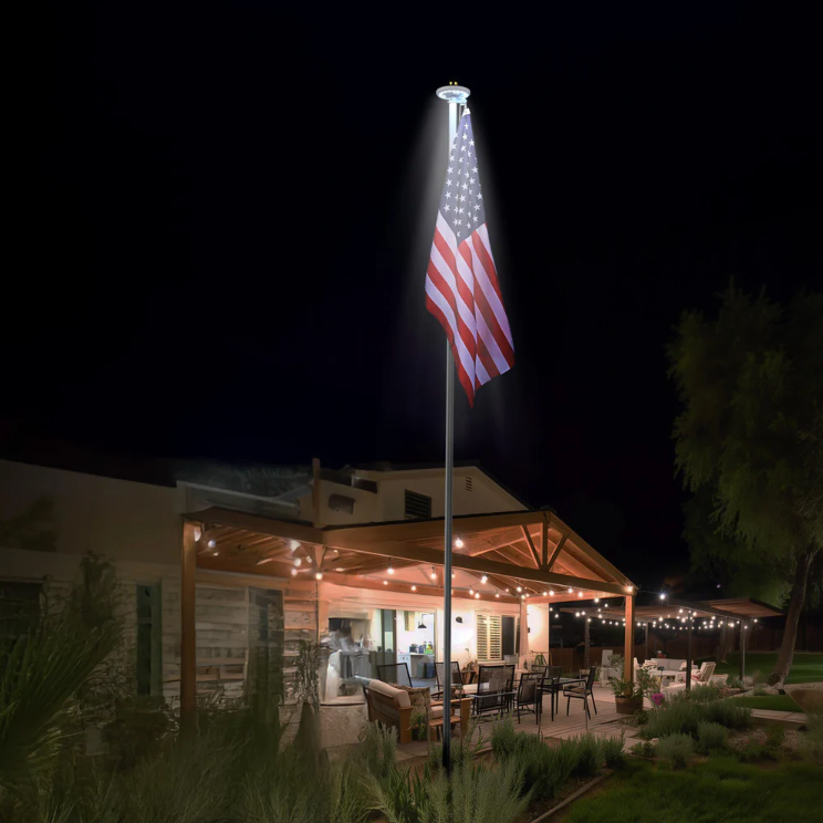 Outdoor setting with a flagpole featuring an American flag at night.