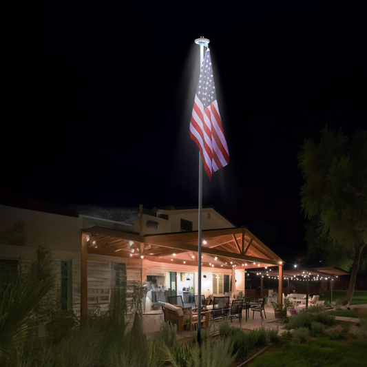 Outdoor setting with a flagpole featuring an American flag at night.